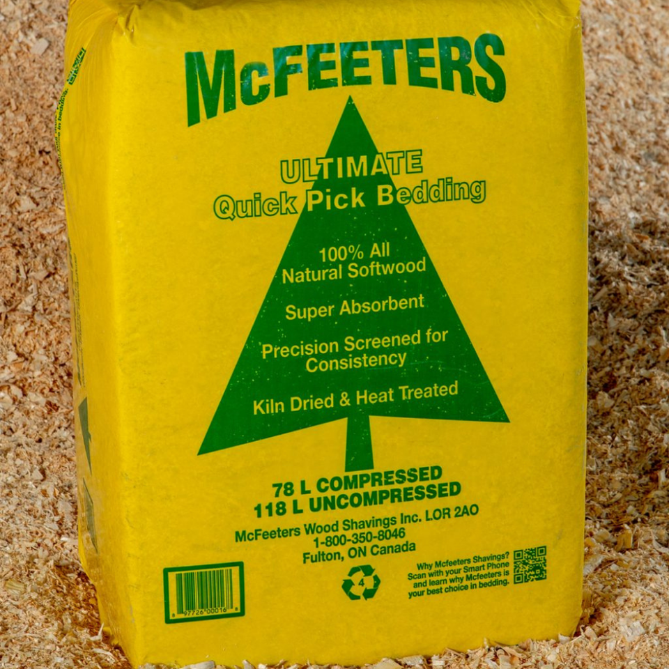 Yellow bag of McFeeters Quick Pick Bedding, featuring a green tree logo and text highlighting its natural softwood, absorbency, and eco-friendly qualities.