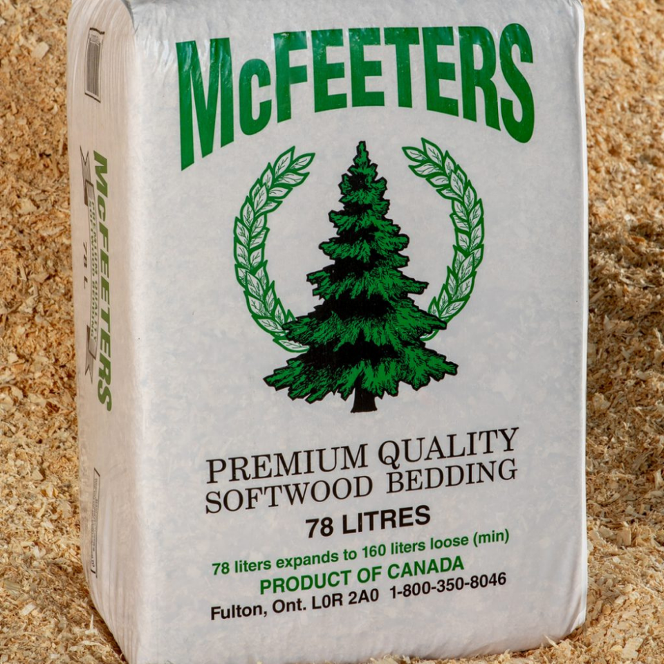 Bag of McFEETERS Premium Quality Softwood Bedding on wood shavings. Green logo with pine tree and laurel. Text indicates 78 liters, expands to 160.